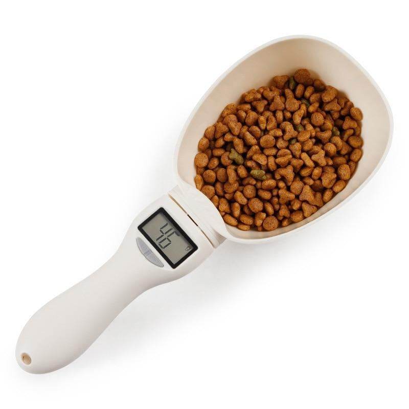 Smart pet food measuring scoop with digital LCD display showing precise food weight, white ABS plastic design.