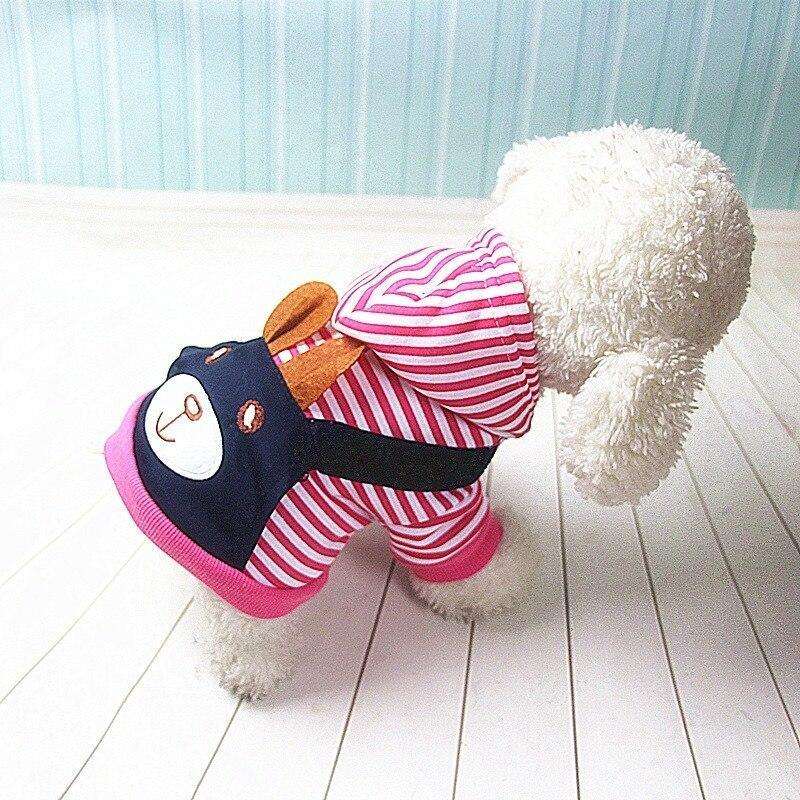 Small white dog wearing a pink and white striped dog hoodie with bear face design.