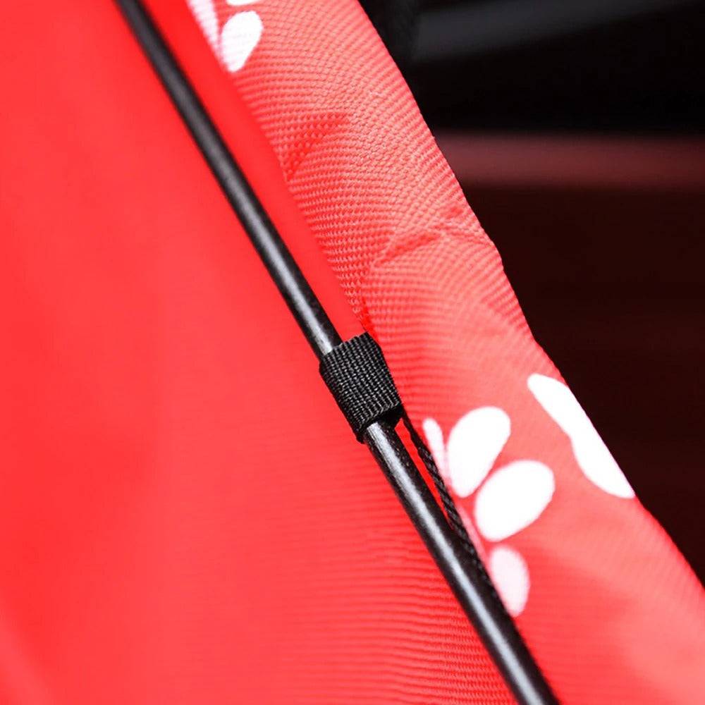 Close-up of red foldable pet car hammock with black support rod and paw print pattern