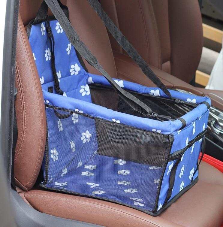 Blue foldable pet car hammock seat with paw prints and black mesh pocket on a brown car seat