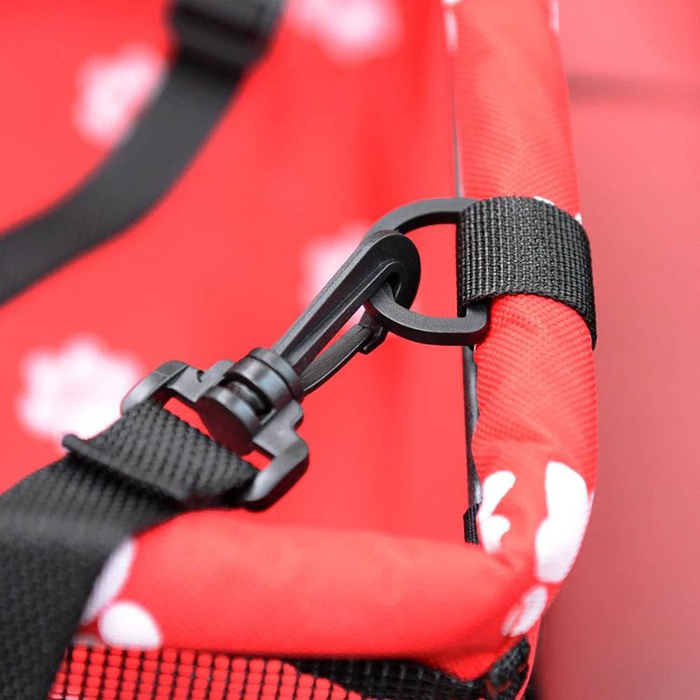 Close-up of secure clip and adjustable strap on red pet car hammock seat with paw print pattern